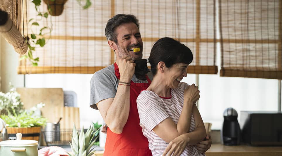 Couple dancing in the kitchen while cooking