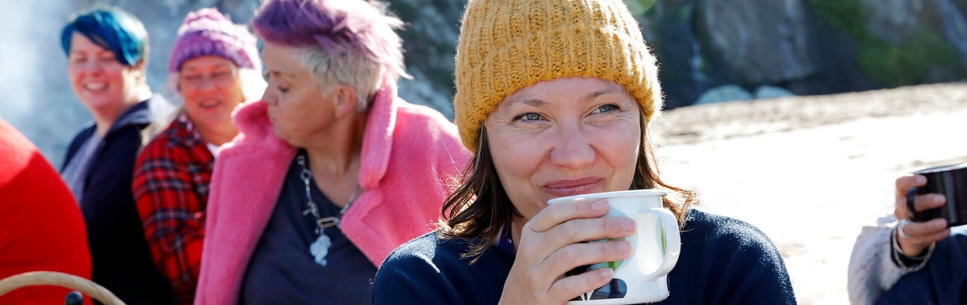 women drinking hot drink on the beach